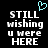 Pixelated text reads 'STILL wishing u were HERE' with a cyan heart symbol above, on a black background.