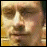 Pixelated of six showing a person's face and red text reading 'brandon d:ca m:ll0' on patterned backgrounds