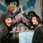 Pixelated image of three people in dark clothing with one person raising a hand, set against a light blue background with pink text.