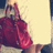 A pixelated image shows a person holding a large red handbag with a smaller red item, against a light background with dark vertical edges.