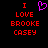 Red pixelated text reads "I LOVE BROOKE CASEY" with a purple heart symbol above the word I on black background.