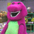 Static 50x50 pixel icon of a pink cartoon dinosaur with green underbelly, wide open mouth showing teeth, and closed eyes against blurred background.