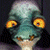 Pixelated character with large yellow eyes and blue-green skin on left, green text 'Original Icons .com' on right against dark background.