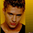 Static 48x48 pixel icon showing a close-up of a person's face with brown hair against a yellow background, wearing a black top.