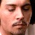 Pixelated close-up of a person's face showing eyes, nose, mouth, and partial beard with light skin tone and dark hair on the right edge.