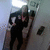 Pixelated image of a person in dark clothing holding a large object against a light background with a small dark shape nearby.