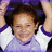 A child in a purple and white shirt with arms raised, smiling broadly across three showing slight head movement