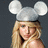 A pixelated image of a person with long blonde hair wearing white mouse ears against a dark gray background.