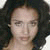 Static pixelated image of a person with dark curly hair and light skin, cropped to show shoulders and upper chest against a white background.