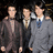 Three pixelated figures in formal attire stand side-by-side against a dark background, each with distinct clothing colors and poses.