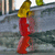 Animated sequence of a figure with yellow hair and red clothing walking on stone steps with a blurred background.