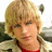 Pixelated static image of a person with light brown hair, wearing red clothing and dark green background elements.