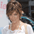 Static 50x50 pixel icon showing a person with brown hair in a white top, partially visible background elements including pink text and dark shapes.