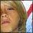 Pixelated close-up of a person's face with light brown hair, closed eyes, and a neutral expression against a blurred background.