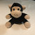Pixelated image of a plush monkey with light brown fur, black hair, and a black sleeveless shirt against a gradient background.