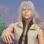 Pixelated image of a person with long light-colored hair wearing a light shirt and dark tie, standing against a blue background.