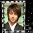 Pixelated portrait of a person with brown hair wearing dark jacket over white shirt against light green background framed by gray border.