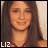 Pixelated portrait of a person with long brown hair, light skin, and a subtle smile, wearing a dark red top with visible straps, set against a light beige background with white text 'LIZ' at bottom left.