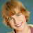A pixelated image of a person with light brown hair smiling, with overlaid text reading "he's so hot i could bake cookies on him!!" and "<33" on a teal background.