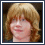 Two pixelated headshots of a person with light brown hair and glasses, one smiling broadly while the other has a neutral expression, both on blue backgrounds.