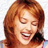 Pixelated close-up of a smiling person with reddish-brown hair against a light background, rendered in low-resolution 256x256 pixels.