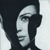 Pixelated grayscale portrait of a person's face in profile view with dark hair and light skin tones, displayed as a static buddy icon on a transparent background.