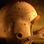 A pixelated close-up of a brown dog's head with glowing eyes and an orange-tinted light source on the right side.
