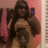 Pixelated static image of a person with long dark hair wearing a sleeveless top against a pink background.