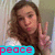 A pixelated image of a person with long brown hair making a peace sign gesture, with a blue banner displaying the word "peace" in pink letters at the bottom.