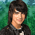 Pixelated image of a person with dark hair wearing a black jacket over a white shirt, standing against a green background with 'CAMP ROCK' text in yellow and red.