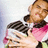 Two pixelated figures in close proximity; one figure wears a pink top with dark collar, the other has dark hair and light skin.
