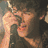 A pixelated image of a person singing into a microphone, with two identical heart-shaped icons featuring multiple faces and text overlays.