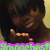 A pixelated image shows a person with dark hair and brown skin holding up four fingers, with green text reading 'Strongest' on a purple background.