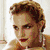 A static image of a woman with styled brown hair, red lipstick, and earrings in two side-by-side showing different poses against distinct backgrounds