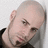 A pixelated image of a person with a shaved head and goatee, positioned on the left side of a black background with red text.