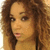 A person with curly brown hair and light skin appears in four -aligned showing subtle facial expression changes