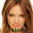 Pixelated close-up of a person with long brown hair, light skin, and a neutral expression, with green text reading 'bloo' at the bottom.