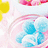 Pixelated image with yellow, pink, and blue shapes including a curved arc over light blue forms on white background.
