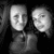 Two grayscale cartoon faces with neutral expressions, side-by-side on a dark background, rendered in low-resolution pixel art style.