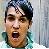 Pixelated static image of a person's face with open mouth and dark hair, wearing teal clothing against light background.
