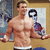 A pixelated image of a shirtless man with short dark hair standing indoors, holding a large black and white object resembling a question mark.