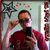 A person in a red shirt takes a mirror selfie with a black phone, adjusting glasses while holding the device up to their face.