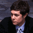 A 48x48 pixel buddy icon split into two sections: a person in formal attire on the left and green text logo on the right, displayed as part of an animated contact sheet with gray transparency background.