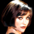 Pixelated static image of a person with short brown hair and bangs against black background, rendered in low-resolution style typical of early 2000s digital art.
