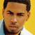 A split-screen image shows a person with short dark hair and light skin on the left against a yellow background, and a silver sedan car front view on the right.