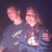 A pixelated image divided into four quadrants with text and a photo of two people in dark clothing against a dark background.