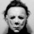 Black-and-white pixelated image of a person with closed eyes, short dark hair, and a smooth mask-like face against a light background.