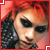Pixelated close-up of a person with red hair and dark clothing, framed by a red border with white corner accents.