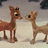 Animated pixel art of two reindeer facing each other on a snowy background with green text overlays changing across frames.