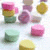 A 4-frame animated contact sheet showing candy-themed icons with pink, yellow, green, and purple candies in a grid layout, where text appears sequentially across frames.